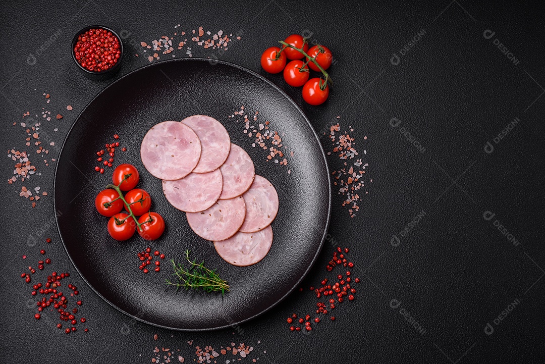 Delicioso presunto fresco cortado em fatias redondas com sal, especiarias e ervas sobre fundo escuro de concreto