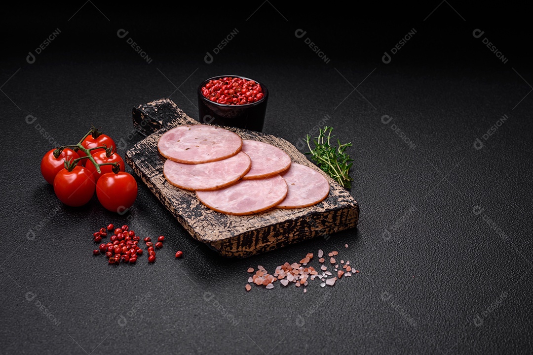 Delicioso presunto fresco cortado em fatias redondas com sal, especiarias e ervas sobre fundo escuro de concreto