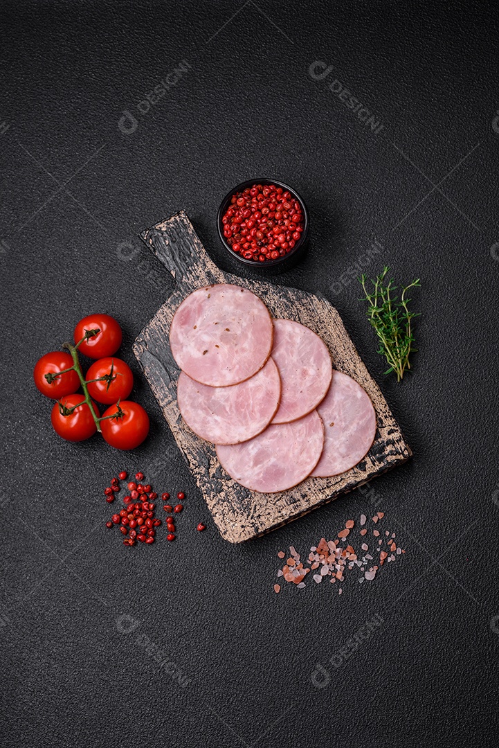 Delicioso presunto fresco cortado em fatias redondas com sal, especiarias e ervas sobre fundo escuro de concreto