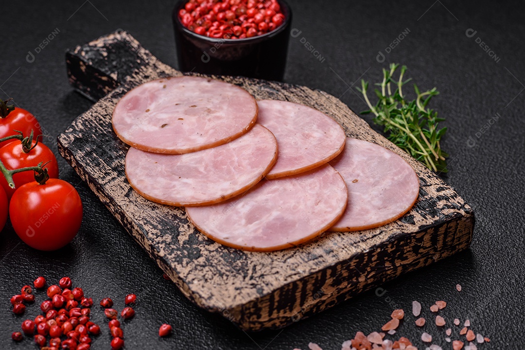 Delicioso presunto fresco cortado em fatias redondas com sal, especiarias e ervas sobre fundo escuro de concreto