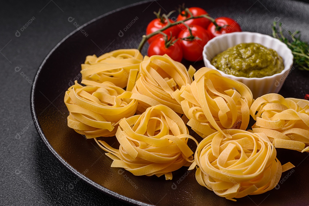 Delicioso molho vermelho picante com sal e especiarias em uma tigela de cerâmica sobre um fundo escuro de concreto