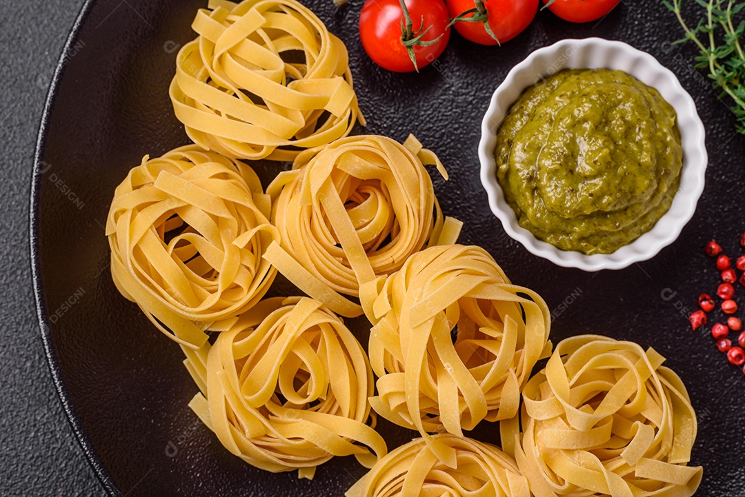 Delicioso molho vermelho picante com sal e especiarias em uma tigela de cerâmica sobre um fundo escuro de concreto