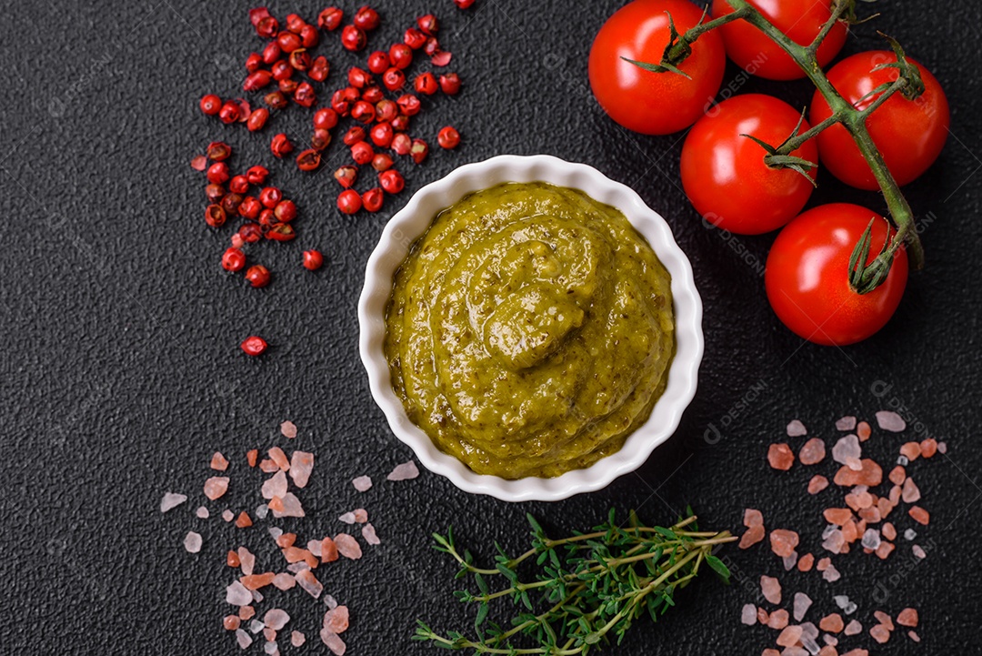 Delicioso molho vermelho picante com sal e especiarias em uma tigela de cerâmica sobre um fundo escuro de concreto