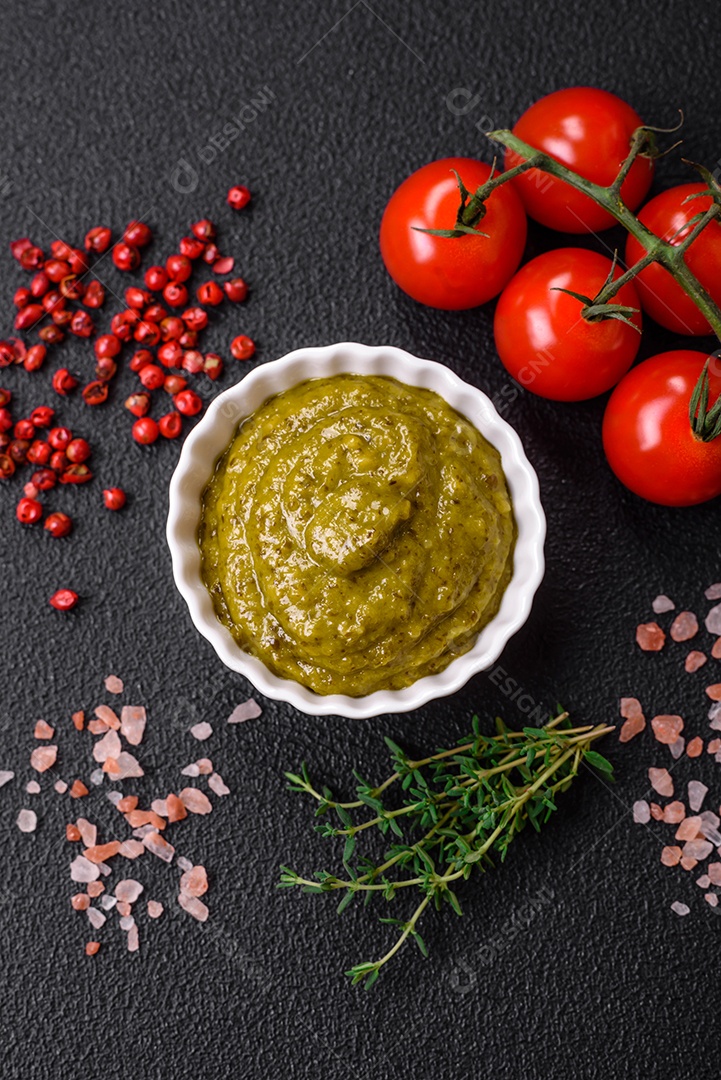 Delicioso molho vermelho picante com sal e especiarias em uma tigela de cerâmica sobre um fundo escuro de concreto
