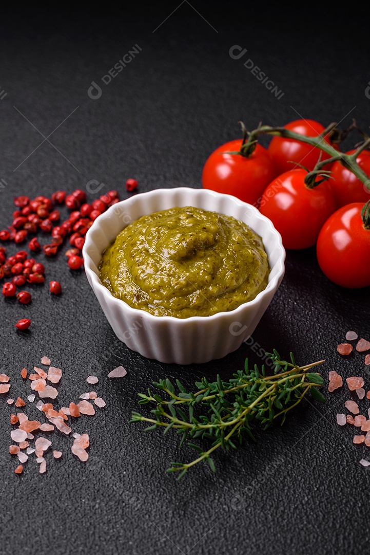 Delicioso molho vermelho picante com sal e especiarias em uma tigela de cerâmica sobre um fundo escuro de concreto