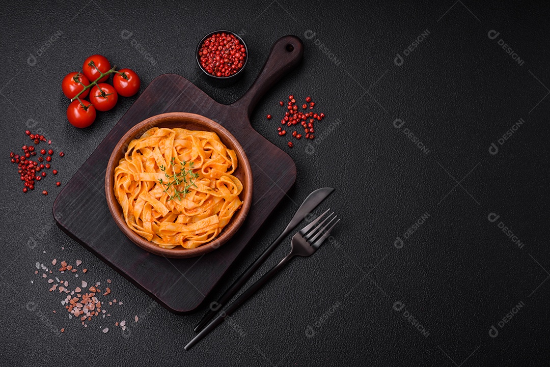 Deliciosa massa fresca com molho pesto, sal, especiarias e ervas num prato cerâmico sobre um fundo de concreto texturizado