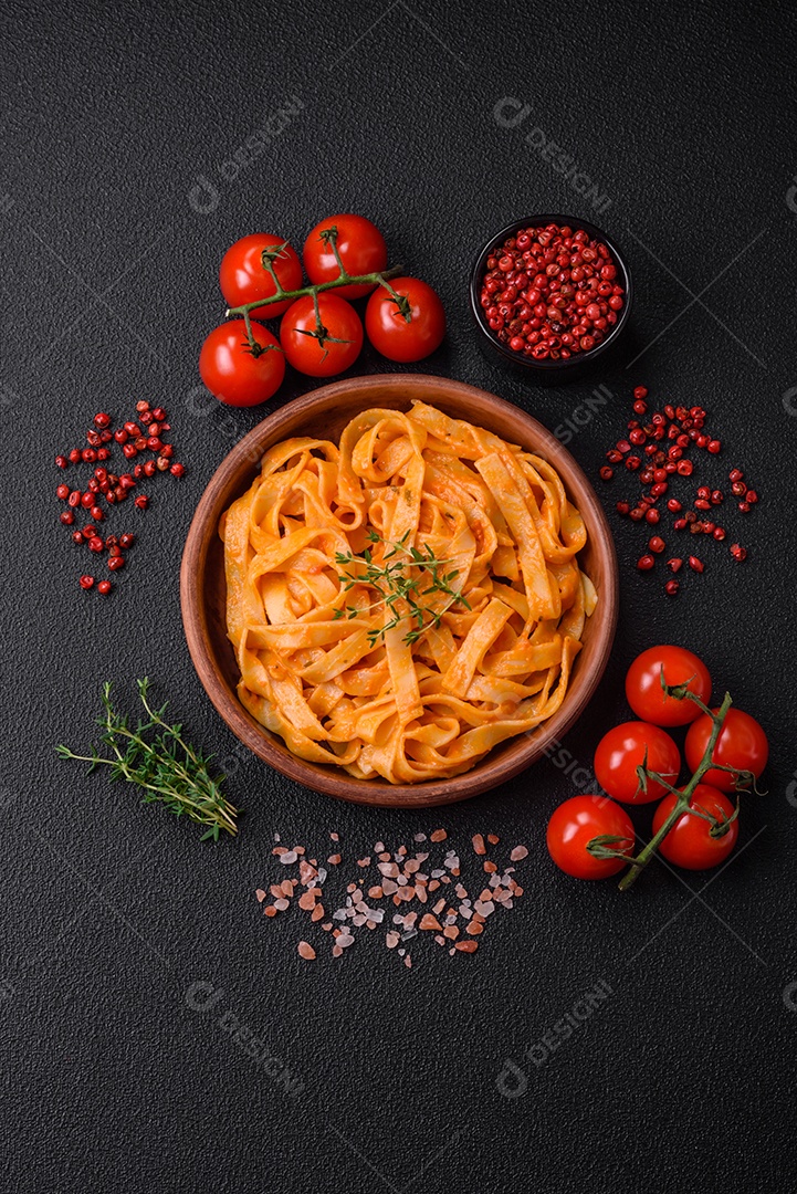 Deliciosa massa fresca com molho pesto, sal, especiarias e ervas num prato cerâmico sobre um fundo de concreto texturizado