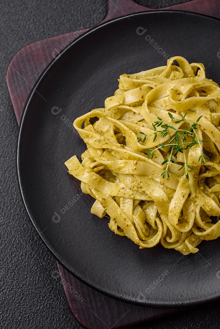 Deliciosa massa fresca com molho pesto, sal, especiarias e ervas num prato cerâmico