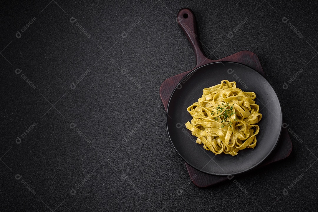 Deliciosa massa fresca com molho pesto, sal, especiarias e ervas num prato cerâmico