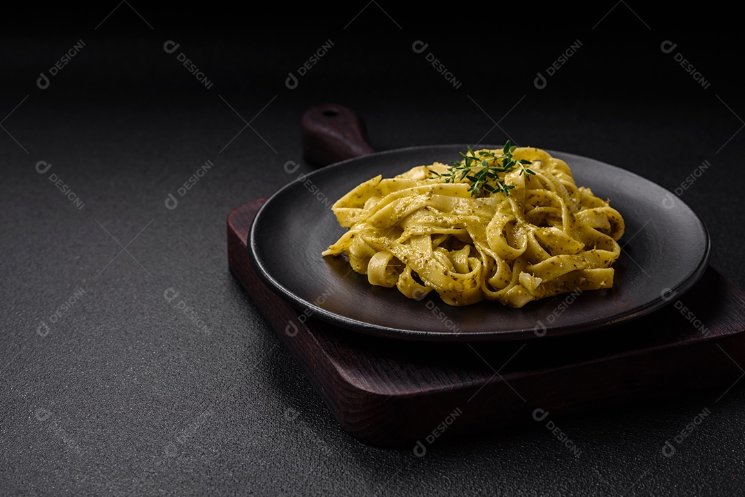 Deliciosa massa fresca com molho pesto, sal, especiarias e ervas num prato cerâmico