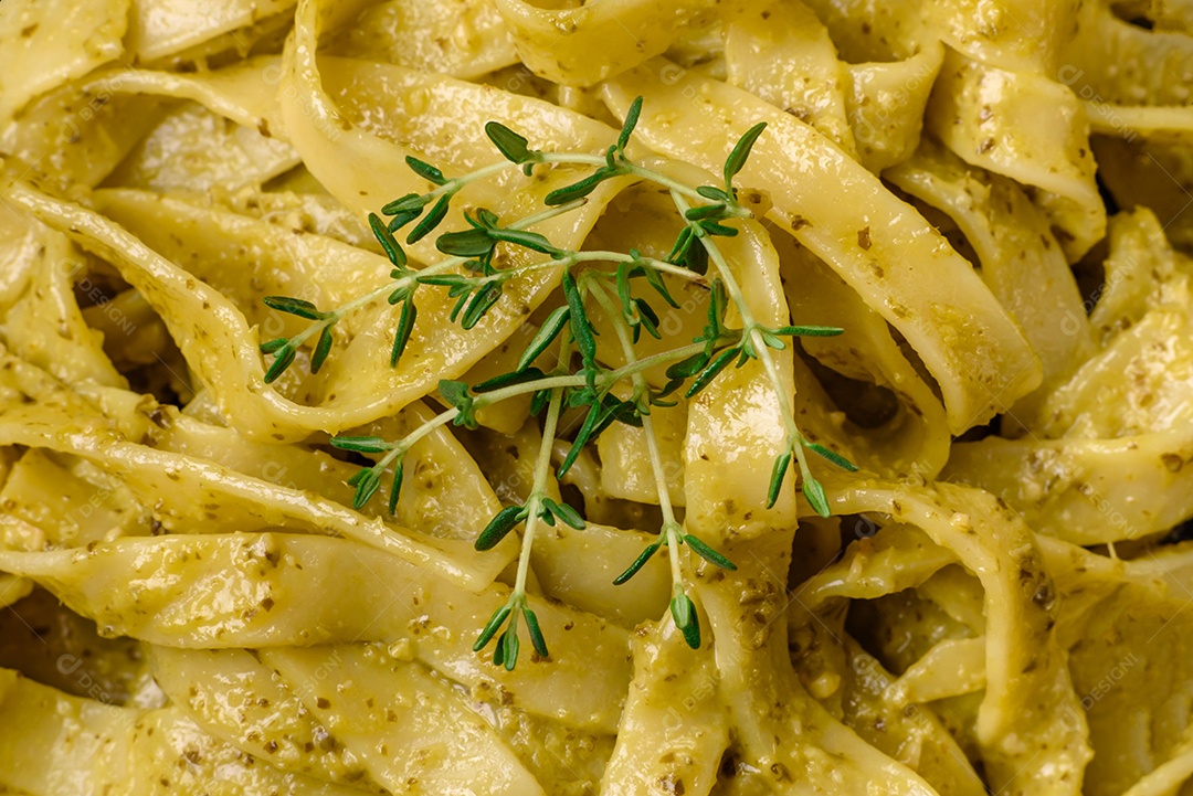 Deliciosa massa fresca com molho pesto, sal, especiarias e ervas num prato cerâmico