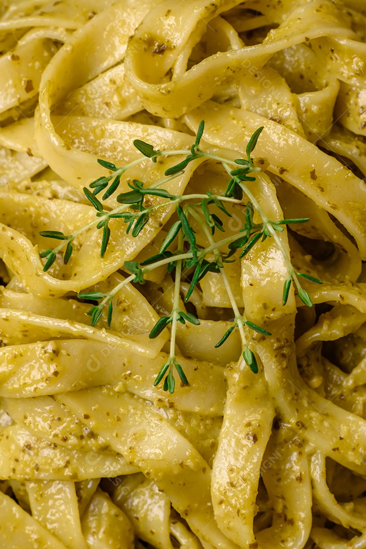 Deliciosa massa fresca com molho pesto, sal, especiarias e ervas num prato cerâmico