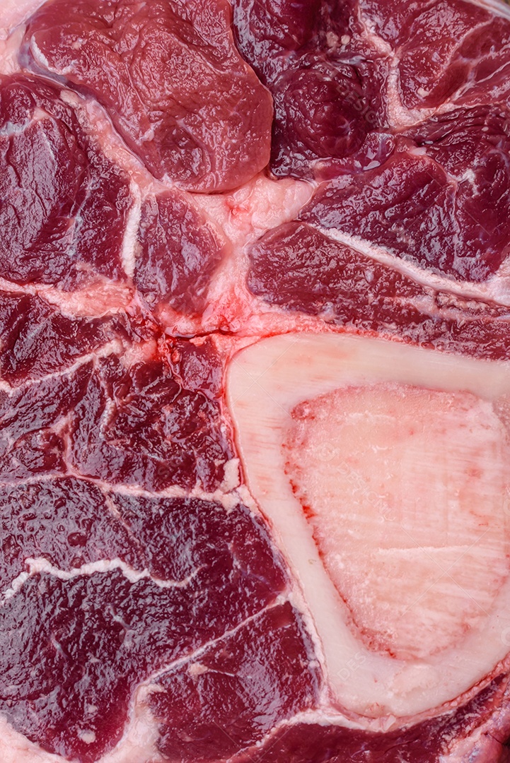 Bife de ossobuco de carne fresca com sal, especiarias e ervas em fundo de concreto texturizado