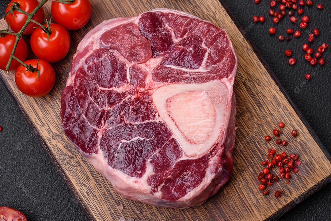 Bife de ossobuco de carne fresca com sal, especiarias e ervas em fundo de concreto texturizado