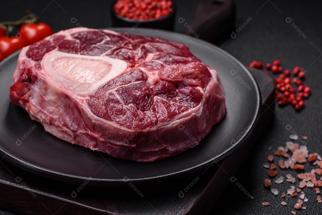 Bife de ossobuco de carne fresca com sal, especiarias e ervas em fundo de concreto texturizado