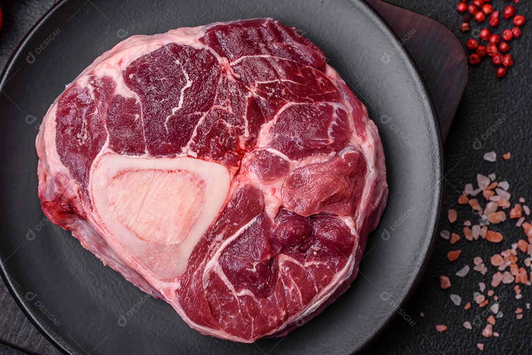 Bife de ossobuco de carne fresca com sal, especiarias e ervas em fundo de concreto texturizado