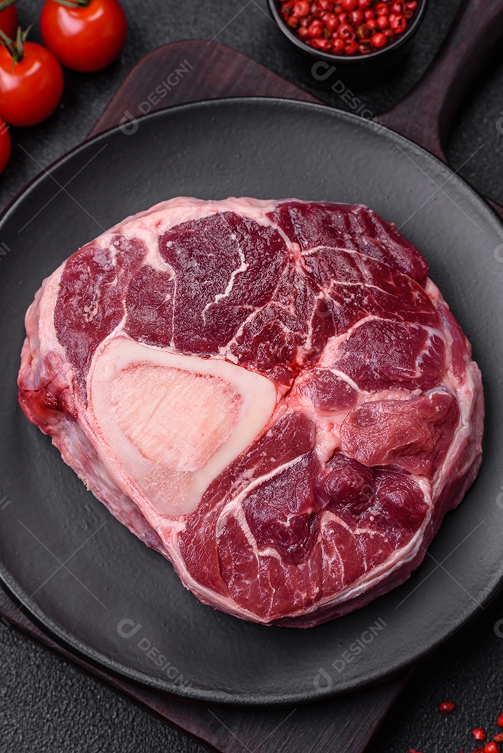 Bife de ossobuco de carne fresca com sal, especiarias e ervas em fundo de concreto texturizado