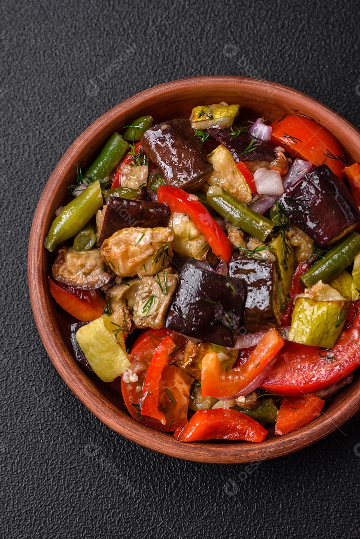 Deliciosa salada fresca de feijão verde, ervilha, pimentão e queijo com sal e especiarias sobre um fundo escuro de concreto