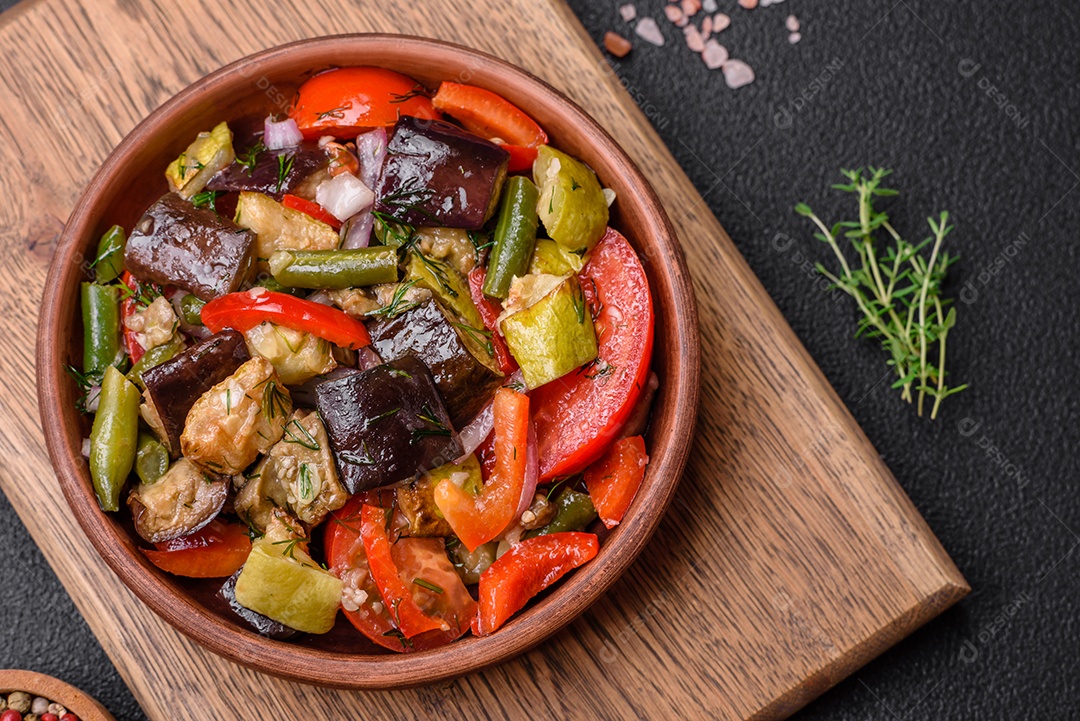 Deliciosa salada fresca de feijão verde, ervilha, pimentão e queijo com sal e especiarias sobre um fundo escuro de concreto
