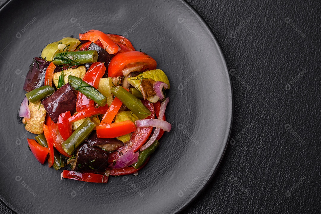 Deliciosa salada fresca de feijão verde, ervilha, pimentão e queijo com sal e especiarias sobre um fundo escuro de concreto