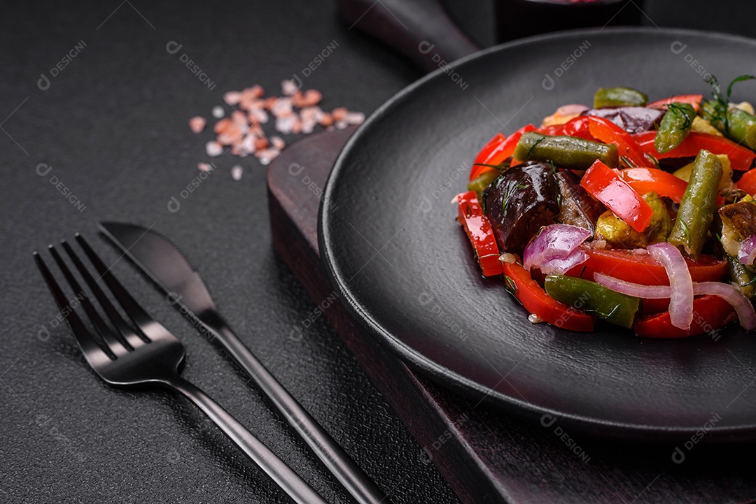 Deliciosa salada fresca de feijão verde, ervilha, pimentão e queijo com sal e especiarias sobre um fundo escuro de concreto