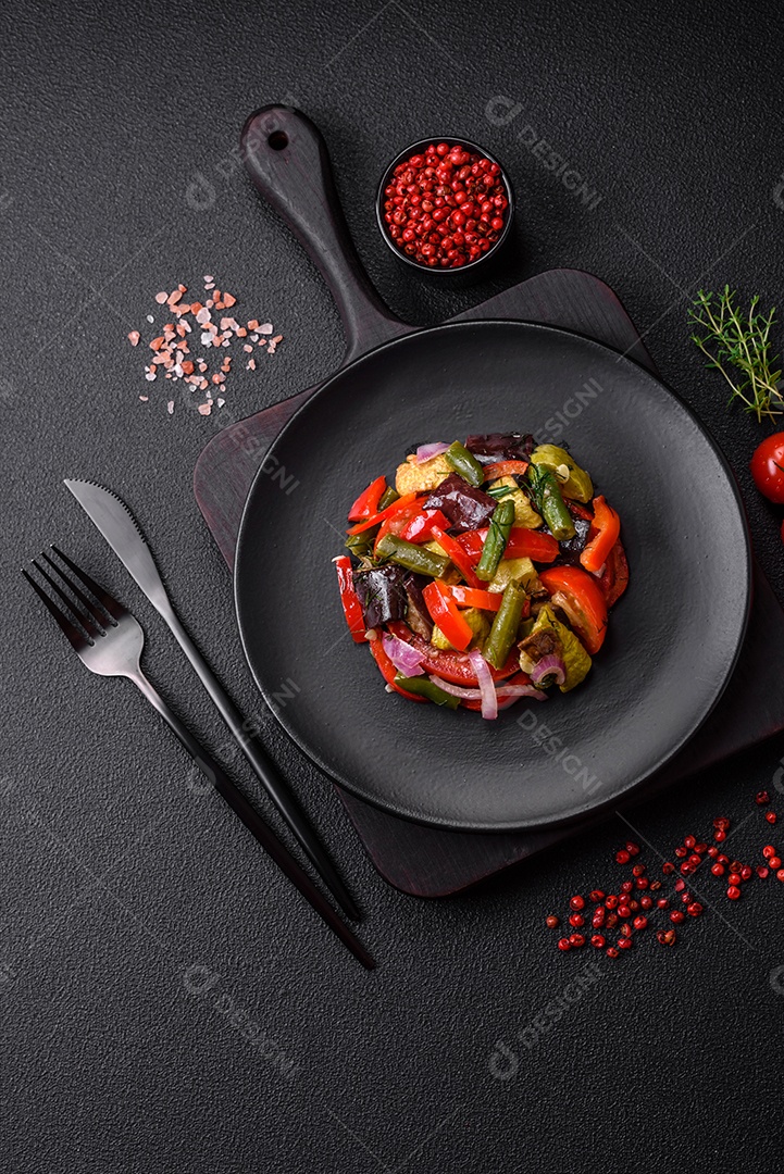 Deliciosa salada fresca de feijão verde, ervilha, pimentão e queijo com sal e especiarias sobre um fundo escuro de concreto