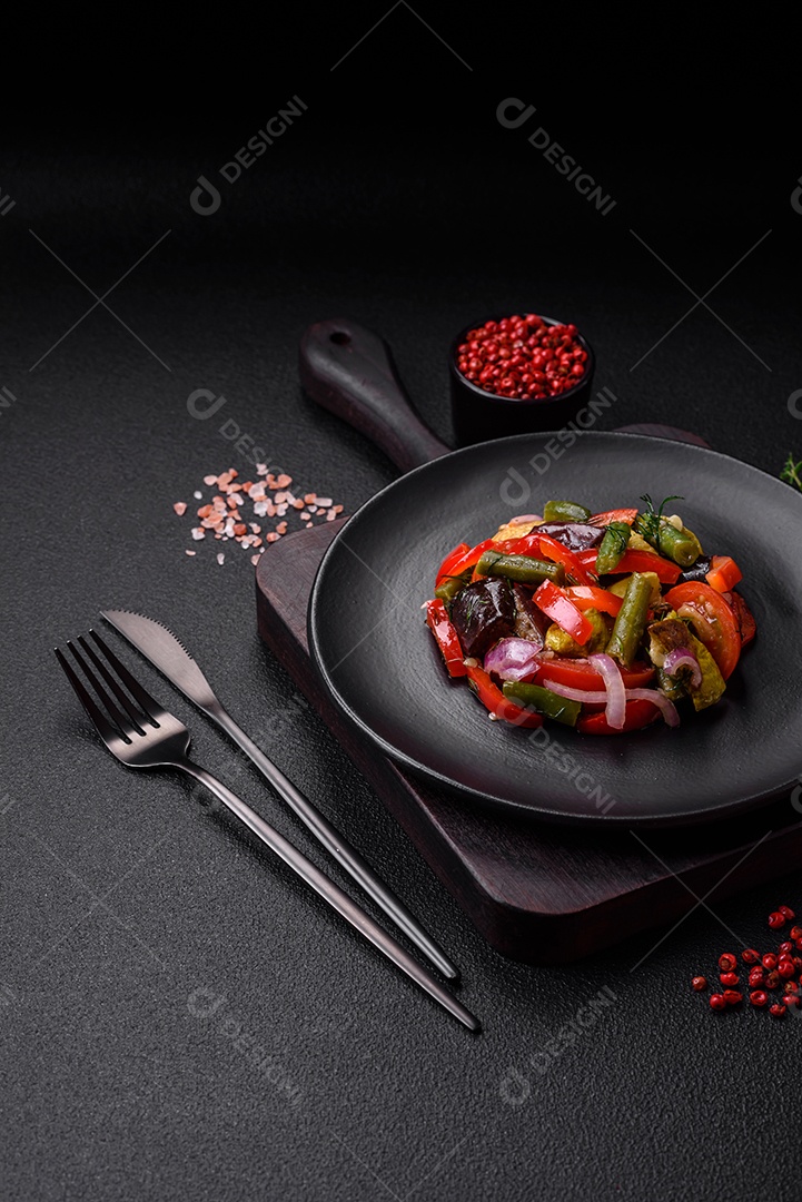 Deliciosa salada fresca de feijão verde, ervilha, pimentão e queijo com sal e especiarias sobre um fundo escuro de concreto
