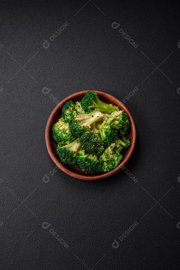 Deliciosos brócolis verdes frescos cozidos em uma placa de cerâmica sobre um fundo de concreto texturizado