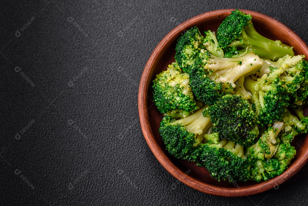 Deliciosos brócolis verdes frescos cozidos em uma placa de cerâmica sobre um fundo de concreto texturizado