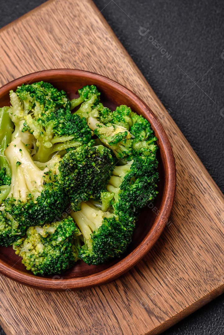Deliciosos brócolis verdes frescos cozidos em uma placa de cerâmica sobre um fundo de concreto texturizado