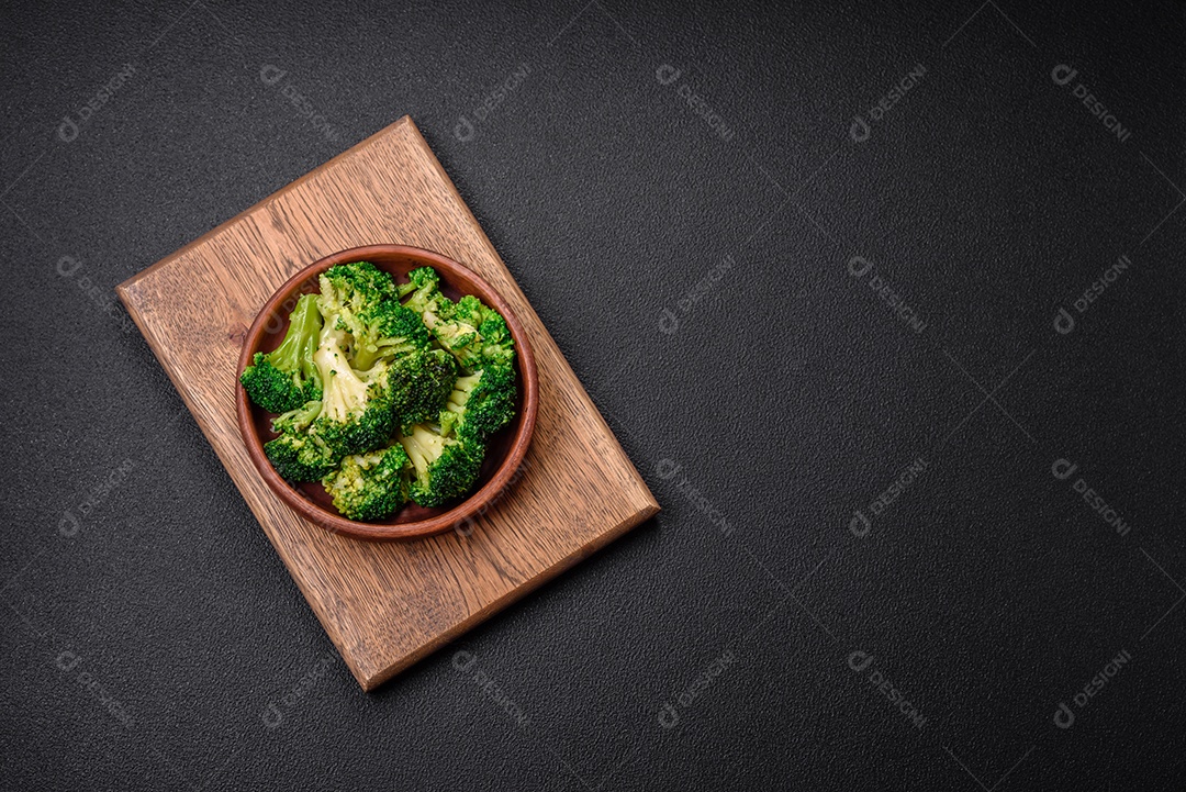 Deliciosos brócolis verdes frescos cozidos em uma placa de cerâmica sobre um fundo de concreto texturizado