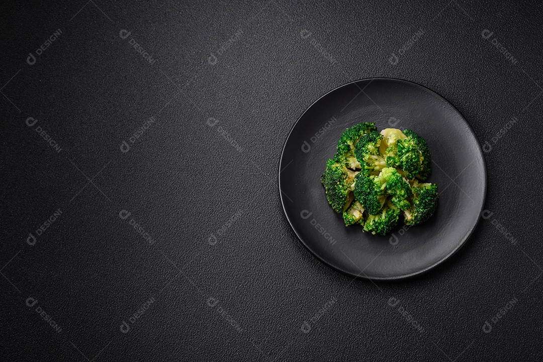 Deliciosos brócolis verdes frescos cozidos em uma placa de cerâmica sobre um fundo de concreto texturizado