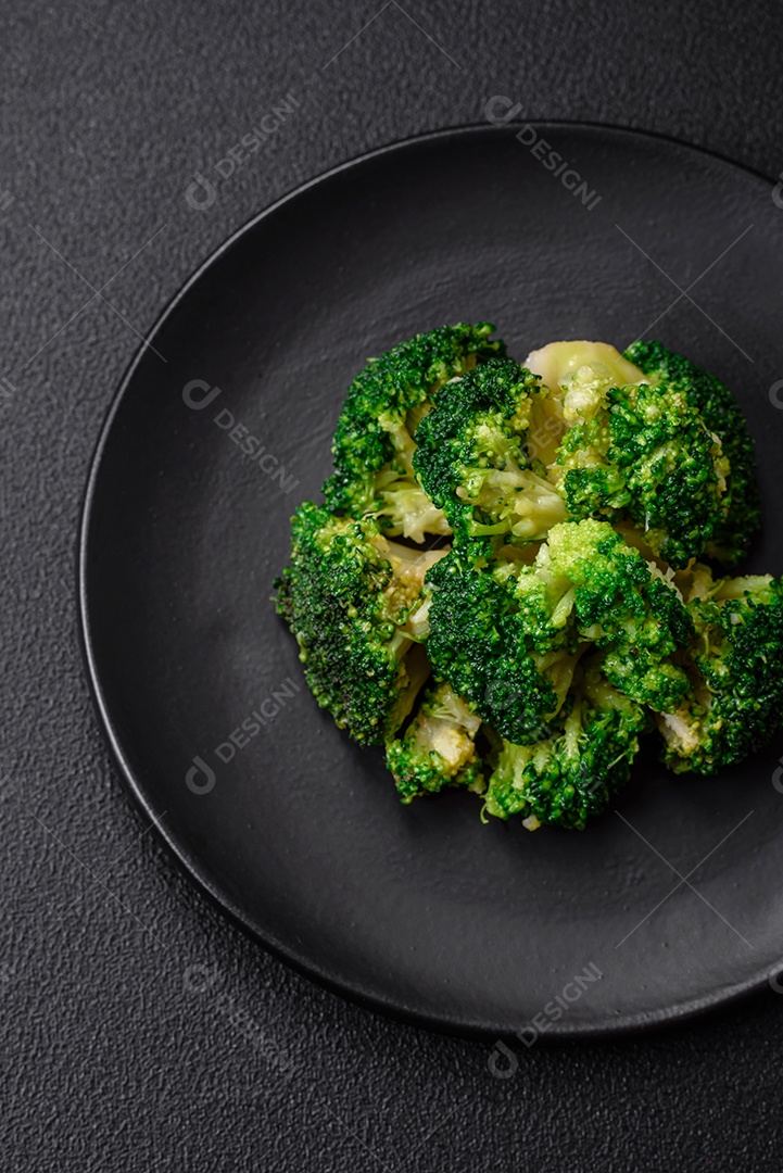 Deliciosos brócolis verdes frescos cozidos em uma placa de cerâmica sobre um fundo de concreto texturizado