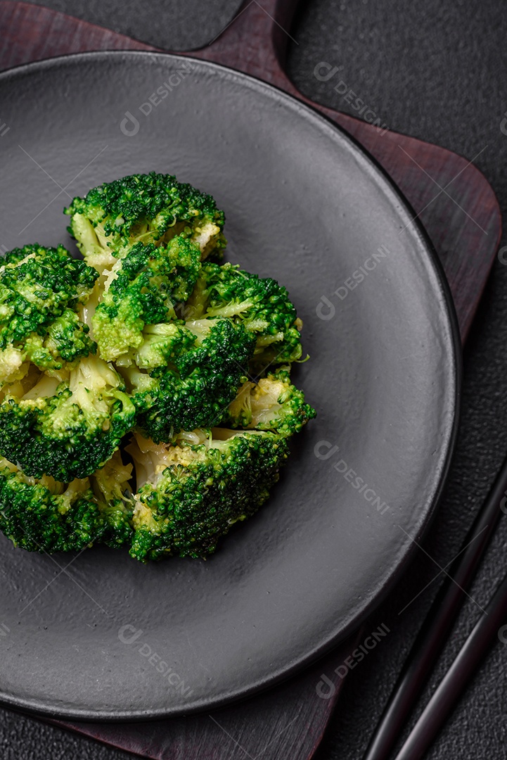 Deliciosos brócolis verdes frescos cozidos em uma placa de cerâmica sobre um fundo de concreto texturizado