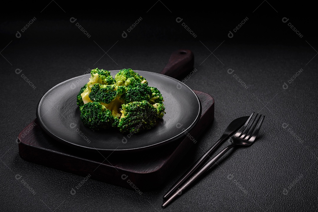 Deliciosos brócolis verdes frescos cozidos em uma placa de cerâmica sobre um fundo de concreto texturizado