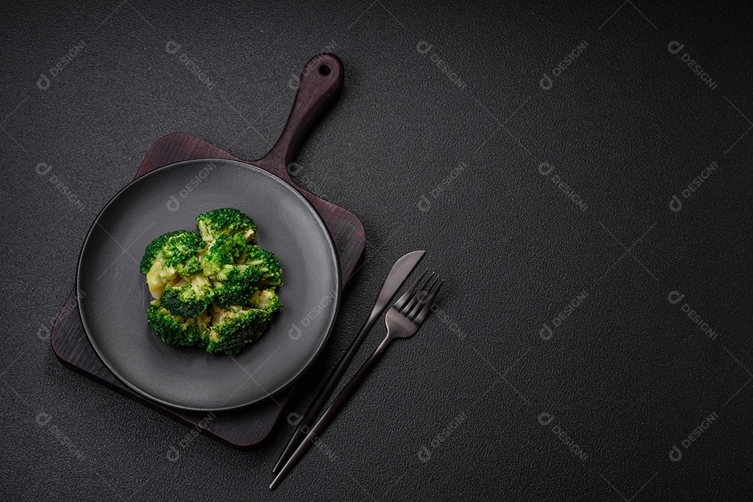 Deliciosos brócolis verdes frescos cozidos em uma placa de cerâmica sobre um fundo de concreto texturizado