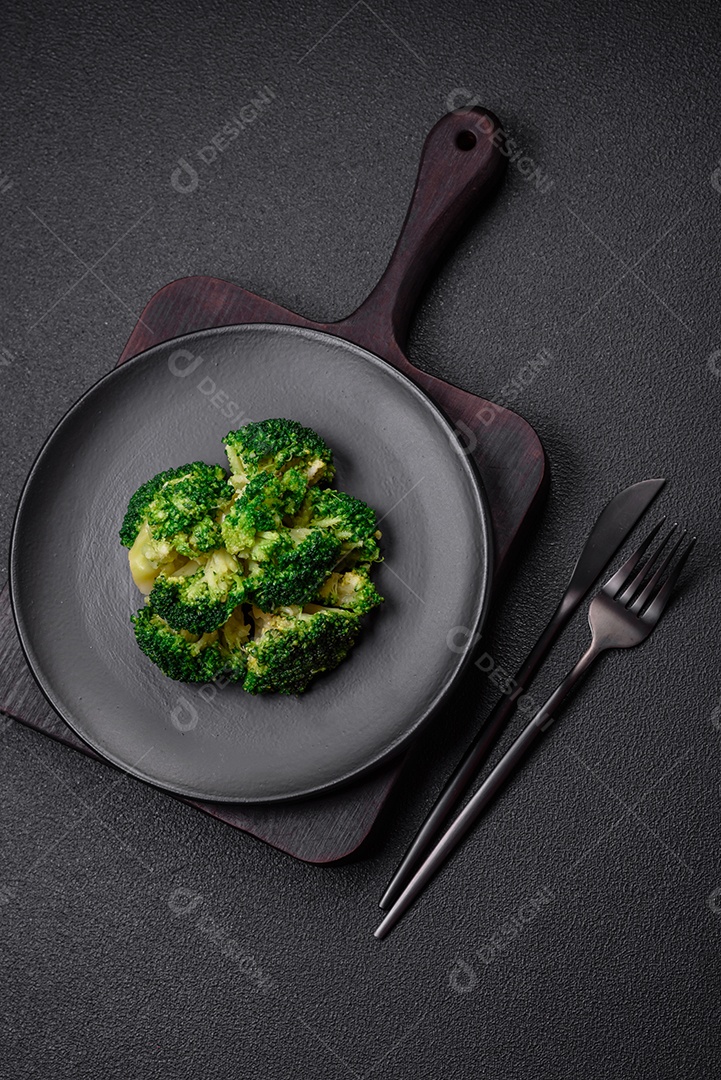 Deliciosos brócolis verdes frescos cozidos em uma placa de cerâmica sobre um fundo de concreto texturizado