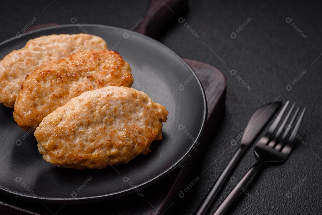 Deliciosas costeletas suculentas ou almôndegas de frango picado com sal e especiarias sobre um fundo de concreto texturizado