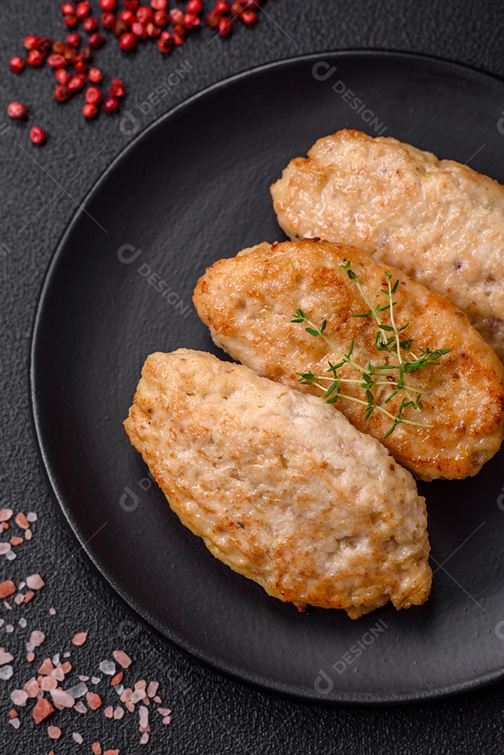 Deliciosas costeletas suculentas ou almôndegas de frango picado com sal e especiarias sobre um fundo de concreto texturizado