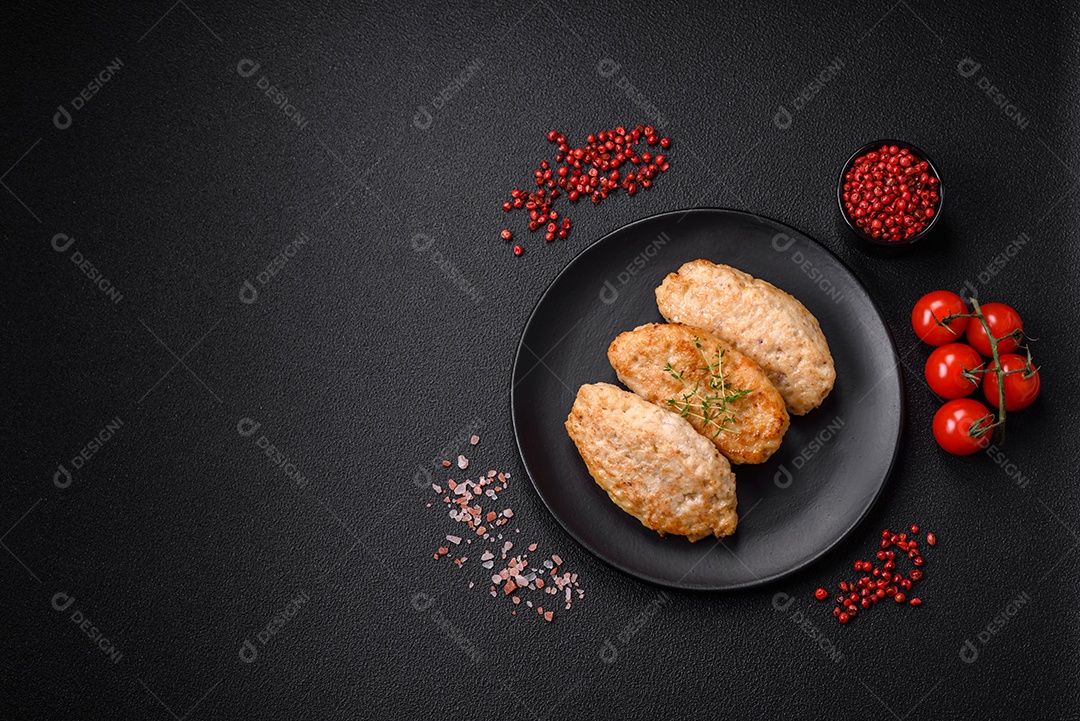 Deliciosas costeletas suculentas ou almôndegas de frango picado com sal e especiarias sobre um fundo de concreto texturizado