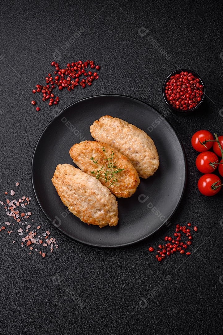 Deliciosas costeletas suculentas ou almôndegas de frango picado com sal e especiarias sobre um fundo de concreto texturizado