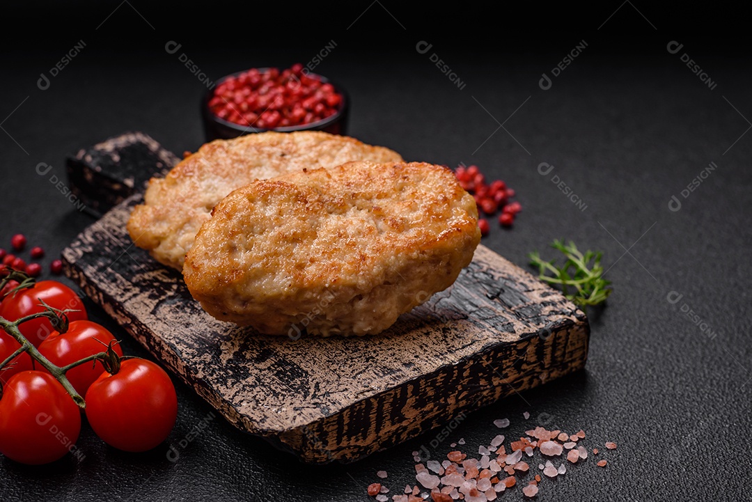 Deliciosas costeletas suculentas ou almôndegas de frango picado com sal e especiarias sobre um fundo de concreto texturizado