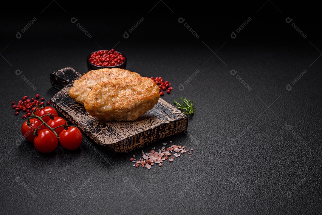 Deliciosas costeletas suculentas ou almôndegas de frango picado com sal e especiarias sobre um fundo de concreto texturizado