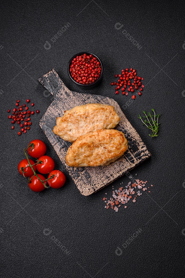 Deliciosas costeletas suculentas ou almôndegas de frango picado com sal e especiarias sobre um fundo de concreto texturizado