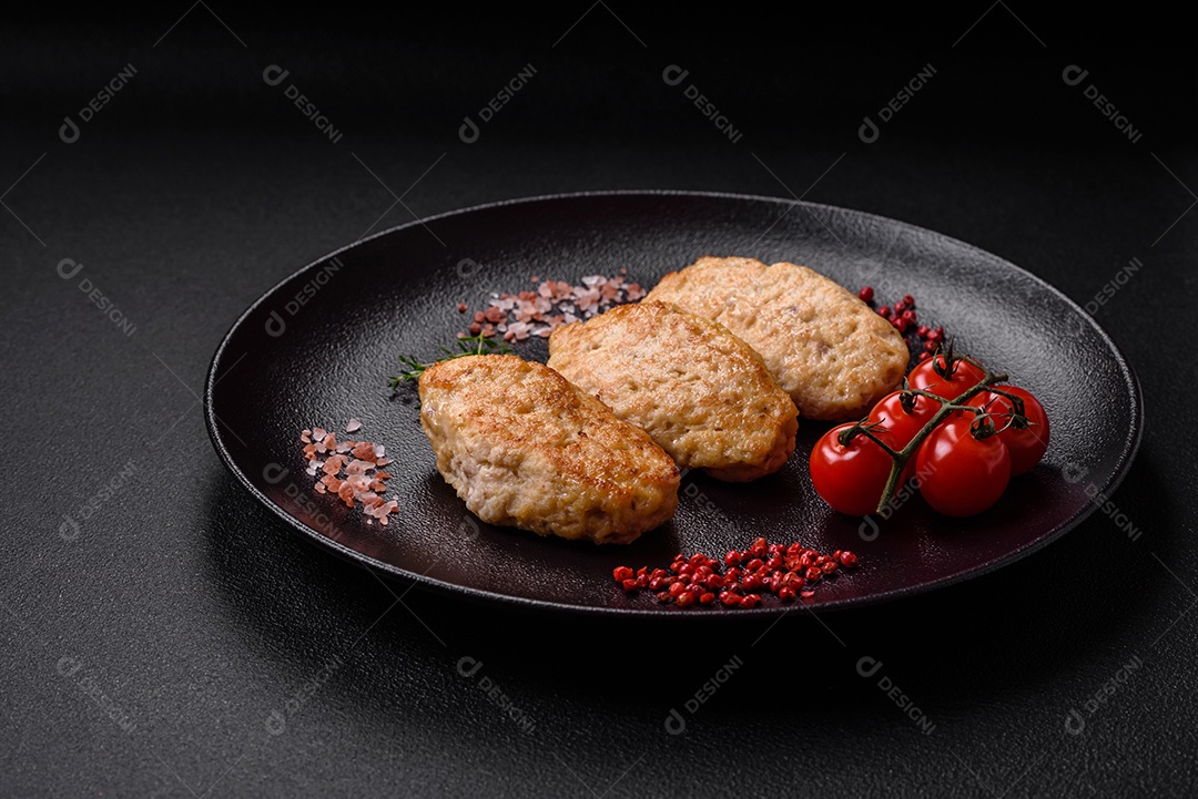 Deliciosas costeletas suculentas ou almôndegas de frango picado com sal e especiarias sobre um fundo de concreto texturizado