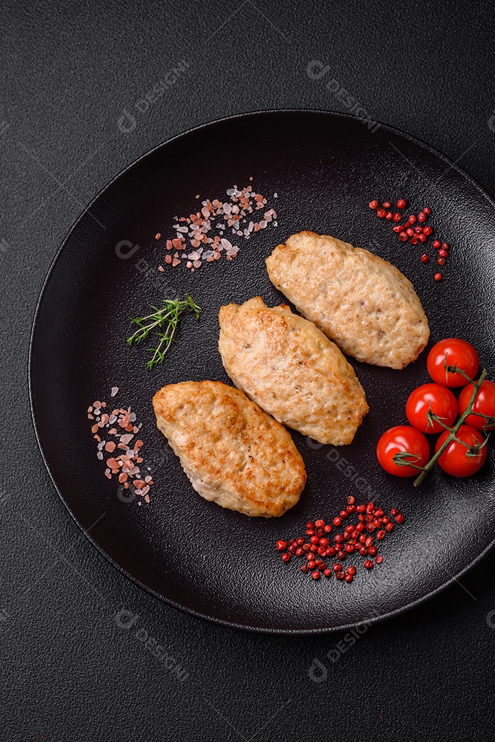 Deliciosas costeletas suculentas ou almôndegas de frango picado com sal e especiarias sobre um fundo de concreto texturizado