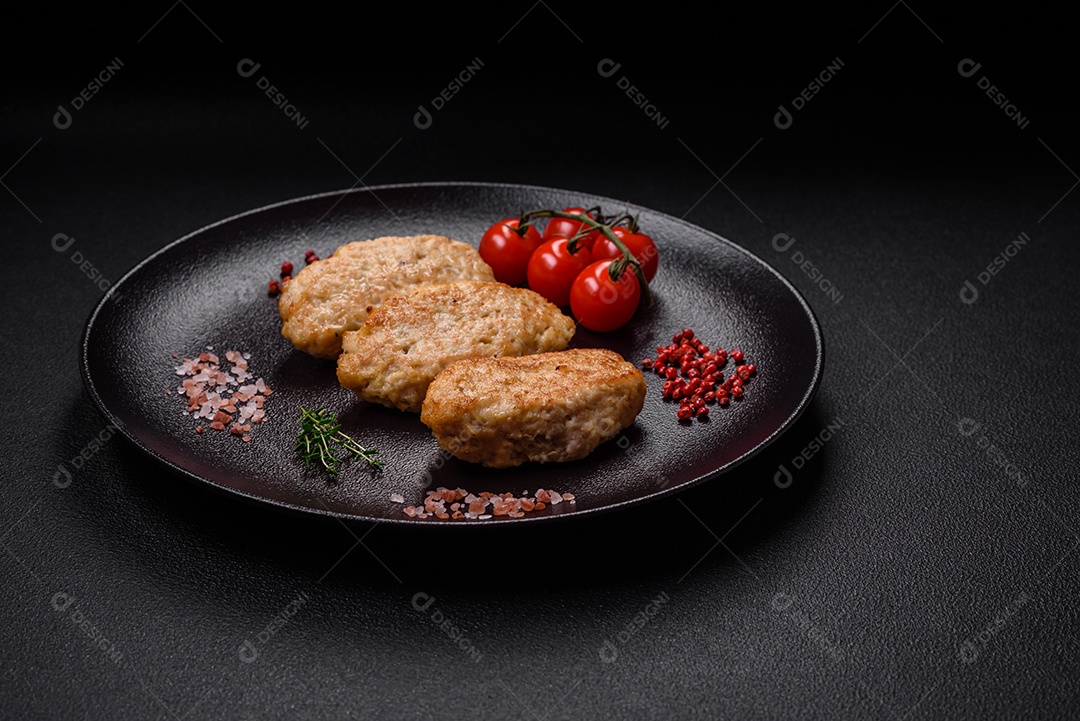 Deliciosas costeletas suculentas ou almôndegas de frango picado com sal e especiarias sobre um fundo de concreto texturizado