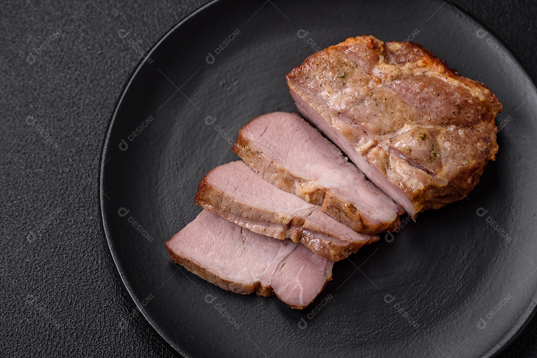 Delicioso suculento bife de porco ou de vaca cozido na grelha com sal e especiarias sobre um fundo de concreto texturizado