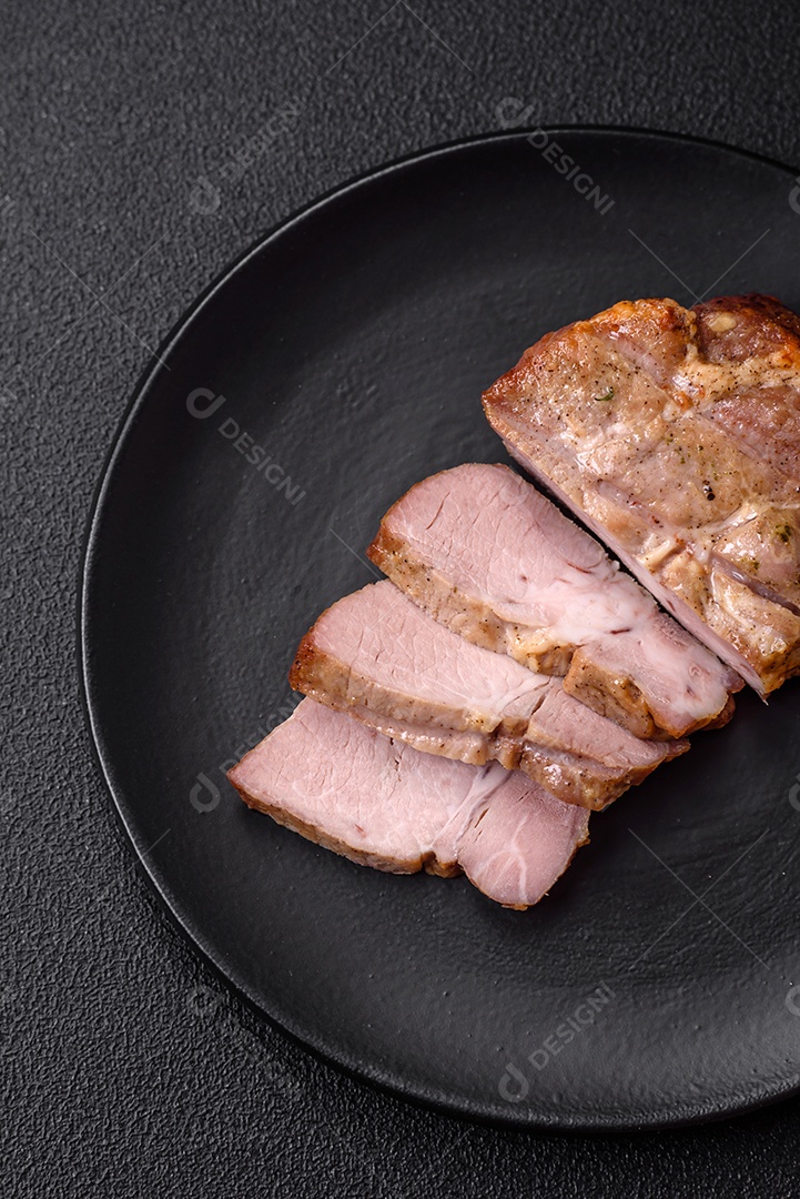 Delicioso suculento bife de porco ou de vaca cozido na grelha com sal e especiarias sobre um fundo de concreto texturizado