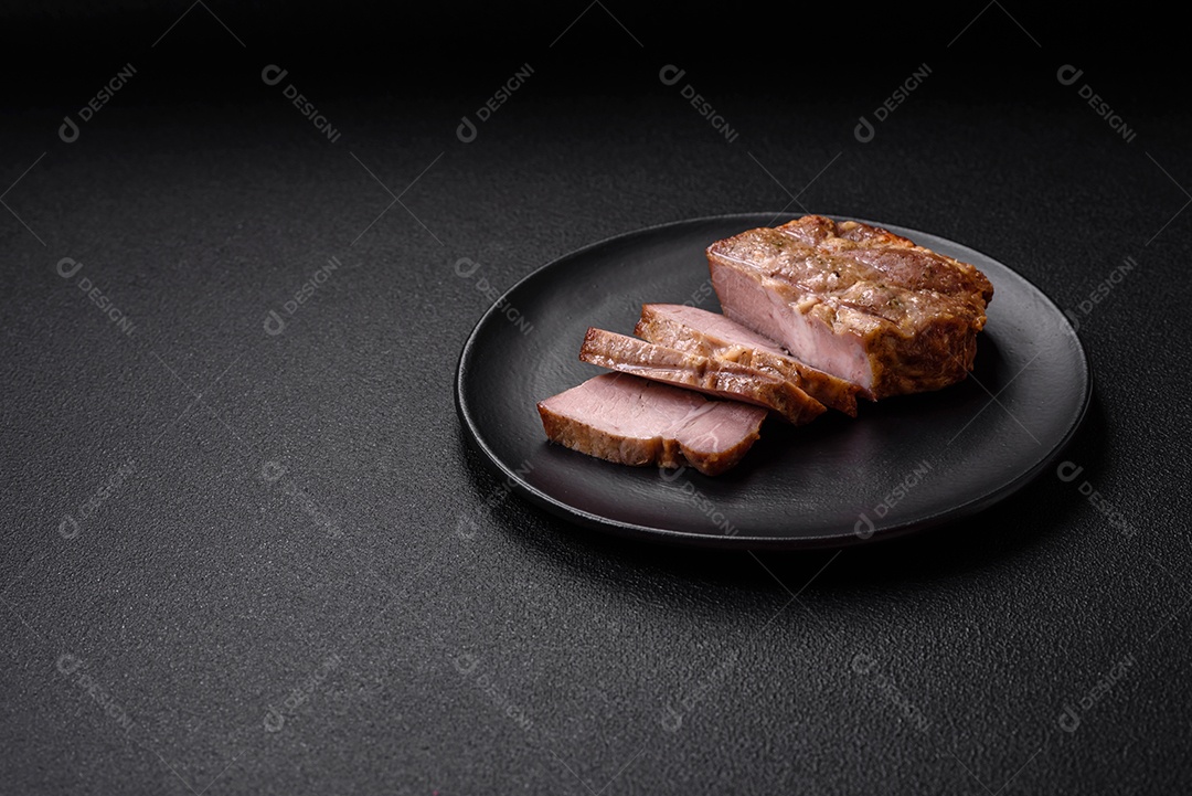 Delicioso suculento bife de porco ou de vaca cozido na grelha com sal e especiarias sobre um fundo de concreto texturizado